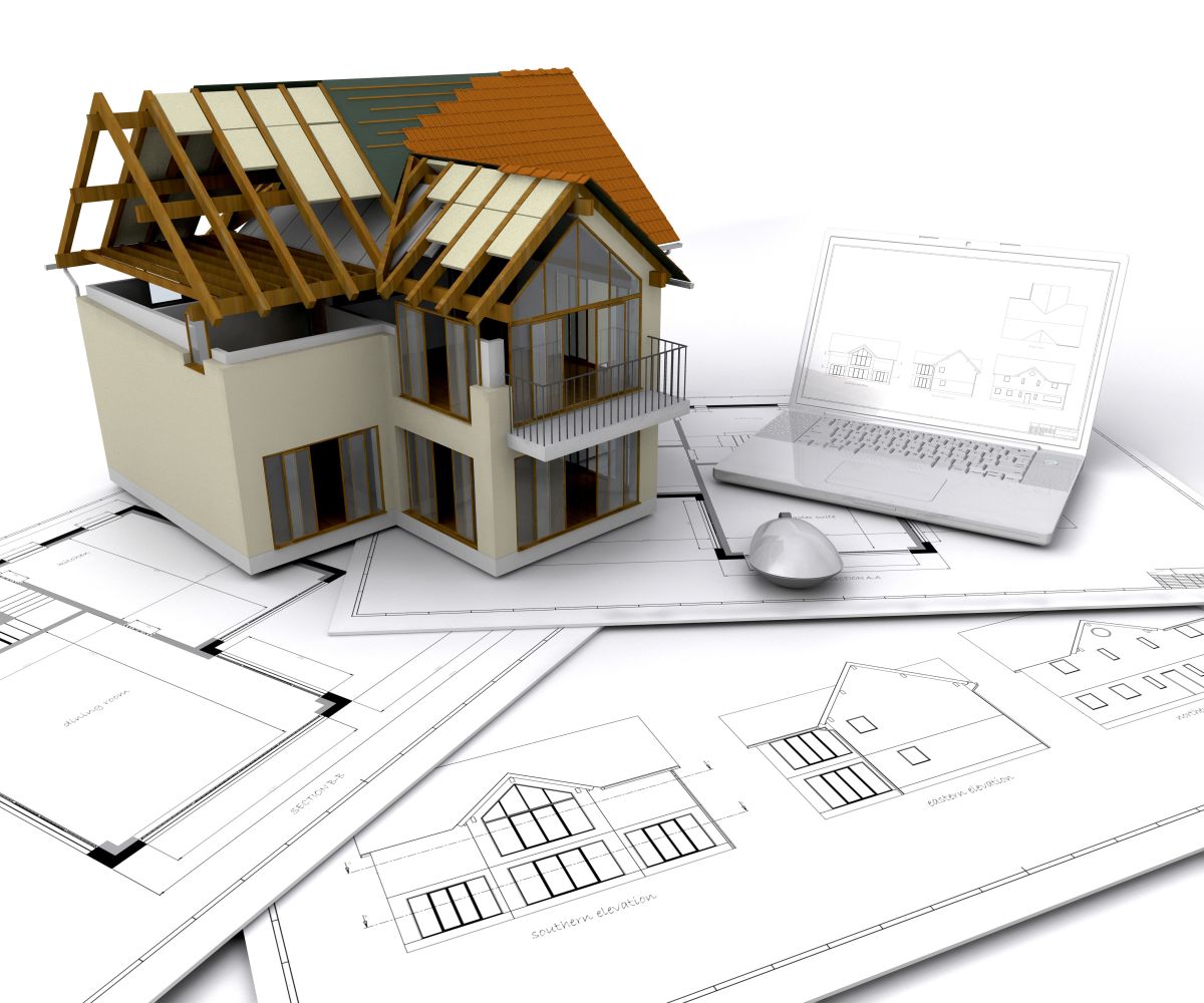 House under construction on plans with laptop